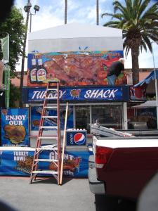Installing the new wrap on the Marquee of food trailer for Turkey Shack at the Del Mar Fair